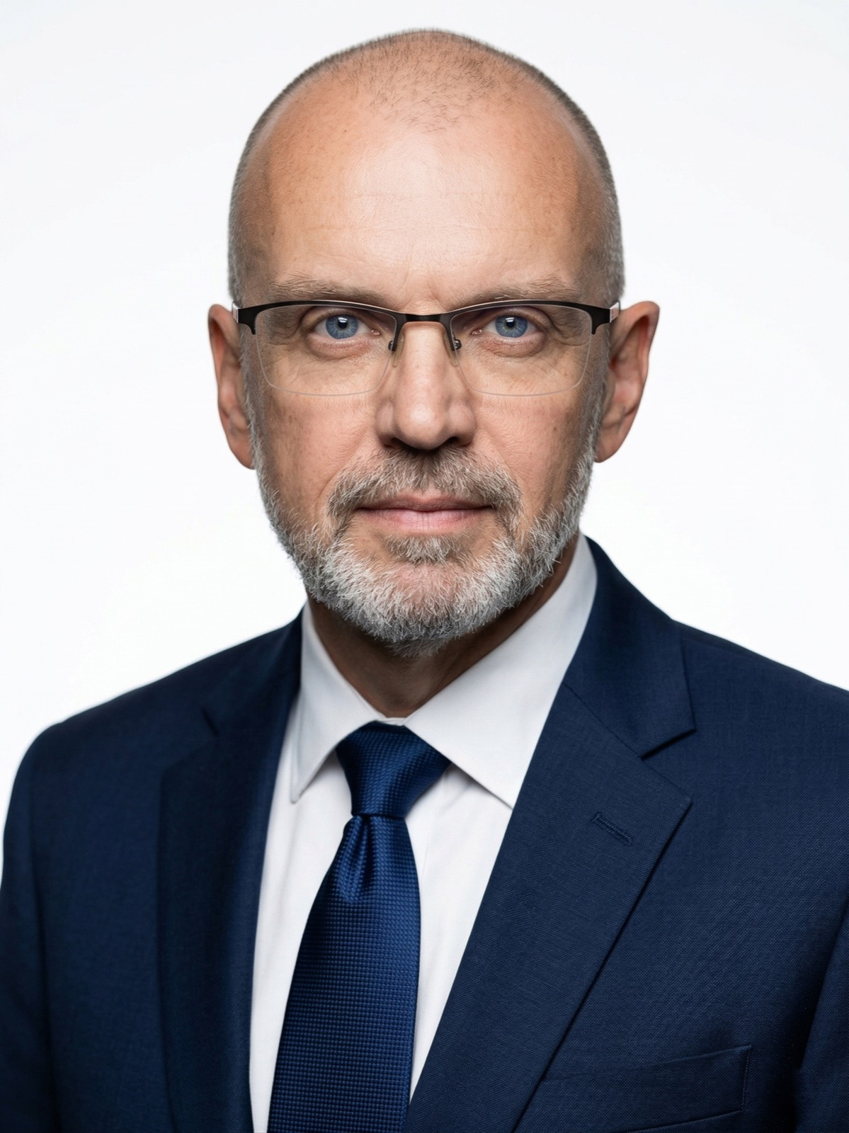 Brent Passmore in a navy suit and glasses, with a short gray beard, facing the camera.